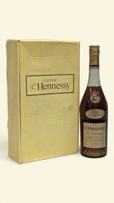La bouteille de Hennessy se trouve à côté d'un carton de vin.