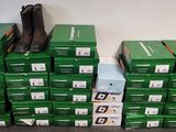 Des cartons de chaussures sont empilés les uns sur les autres par terre