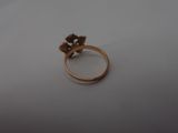 a gold ring with a flower on it sitting on a table