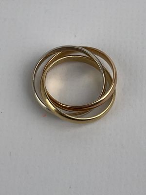 three gold rings on a white surface with a white background