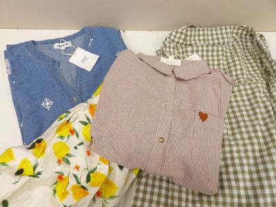 a pile of clothes on a bed with a tag on it