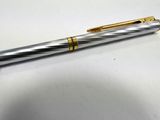a close up of a pen on a table with a white background