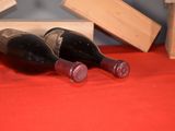 two bottles of wine sitting on a red table cloth