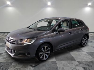 a grey car is parked on a checkered floor in a garage