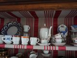 de nombreuses tasses et soucoupes posées sur une étagère dans un vaisselier