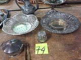 une table en bois sur laquelle sont posés de nombreux objets en argent