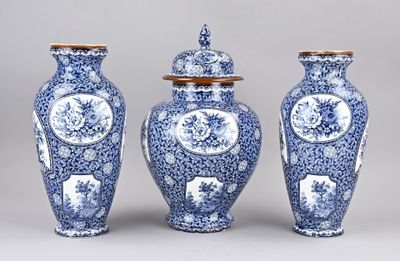 three blue and white vases with lids on a gray surface