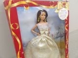 barbie doll in a box with a gold dress and gold earrings
