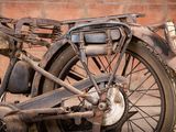 a old motorcycle that is parked in front of a brick wall