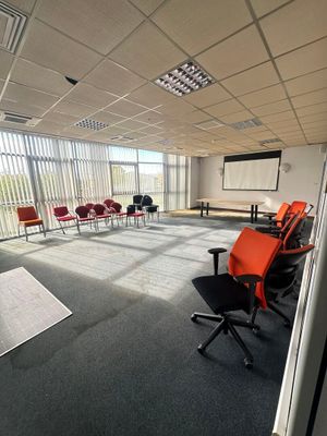 a room with chairs and a projector screen in it