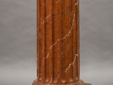 a close up of a red marble column on a gray background