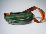 a green purse with a brown strap on it