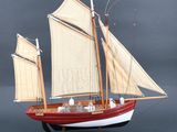 une maquette de voilier avec ses voiles, posée sur un socle
