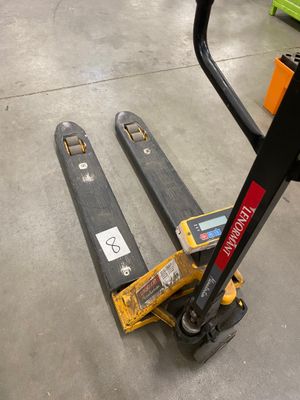 un chariot élévateur posé au sol dans un entrepôt