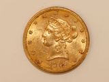 a close up of a gold coin on a white surface