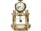 une petite horloge posée sur un socle, entourée d'une chaîne