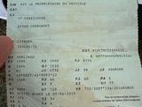 une personne tient un ticket de caisse à la main, avec une photo de ce ticket
