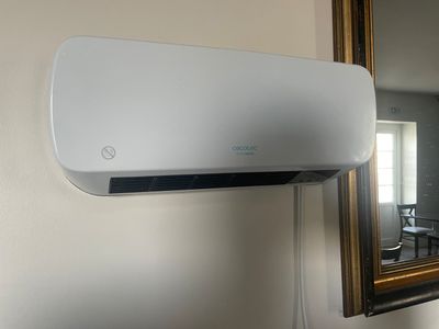un climatiseur blanc accroché au mur à côté d'un miroir