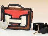 a purse and a key on a white surface