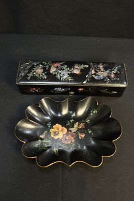 une petite boîte noire ornée d'un motif floral