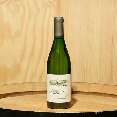 une bouteille de vin posée sur un tonneau en bois