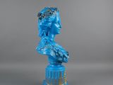 a close up of a blue statue of a woman with a crown on her head