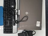un ordinateur portable, un clavier, une souris et d'autres appareils électroniques posés sur une table