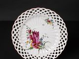 a white plate with a floral design on it on a black background