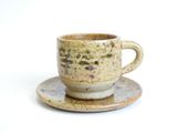 a cup and saucer sitting on a saucer
