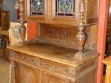 a wooden cabinet with stained glass windows in a room
