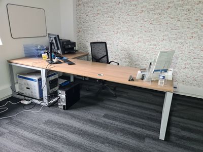 un bureau sur lequel se trouvent deux ordinateurs et un écran