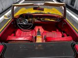 a red and yellow convertible car parked on the side of the road