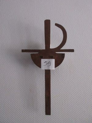 une croix en bois sur laquelle est accrochée une pancarte, posée sur une surface blanche