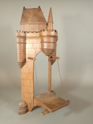 a wooden model of a castle on a stand