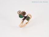 an image of a gold ring with green and white stones