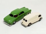 two toy cars sitting next to each other on a white surface