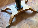 a black vase on a wooden stand on the floor