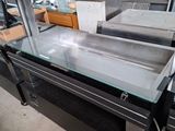 une table en verre avec un plateau en verre dans un entrepôt
