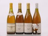 quatre bouteilles de vin sont alignées sur une table