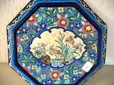 un gros plan d'une assiette décorée d'un oiseau et de fleurs