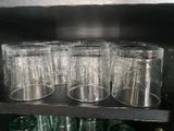 many glasses that are on a shelf in the kitchen