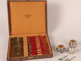une boîte contenant des bougies et des cuillères argentées et rouges