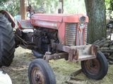 a red tractor that is parked in the grass