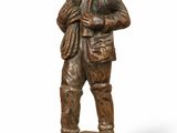 bronze statue of a man with a hat and jacket on a wooden base