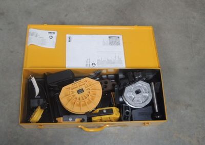 une boîte jaune posée par terre, contenant des outils