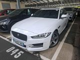 a white jaguar parked in a parking lot with other cars