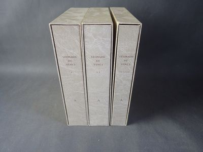 trois livres sont empilés sur une surface grise