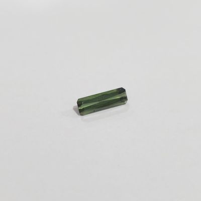 a piece of green tourmaline on a white surface