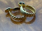 two rings sitting on a table with a gold ring on it