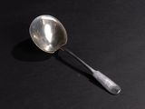 a silver spoon with a spoon handle on a black surface
